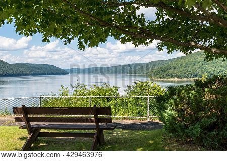 A Wooden Park Bench In Mead Township, Pennsylvania, Usa Overlooking The Allegheny Reservoir In The A