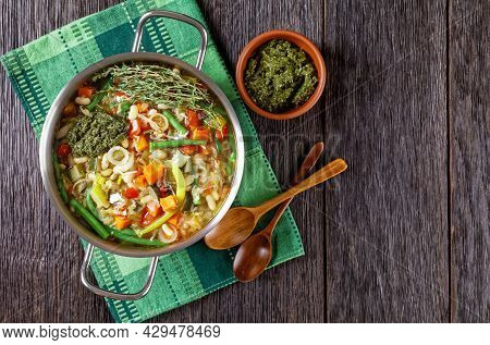 Soupe Au Pistou, French Vegetable Bean Soup With Basil Sauce Pesto And Herbs In A Metal Pot On A Dar