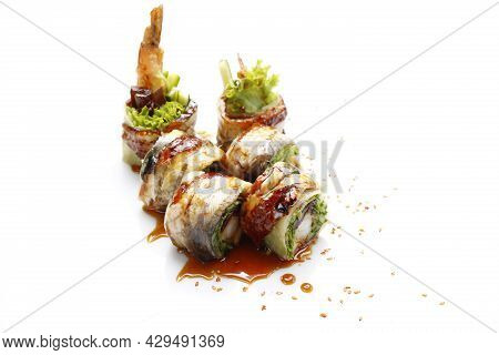 6 Piece Sushi Set With Eel, Shrimp In Tempura, Cucumber, Topped With Dressing, On A White Background