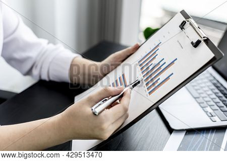 Woman Pointing To A Sales Data Sheet, A Sales Manager Is Looking At A Sales Summary Of Employees In