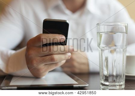 Man met smart telefoon in de hand, onscherpe achtergrond, zelfs glas