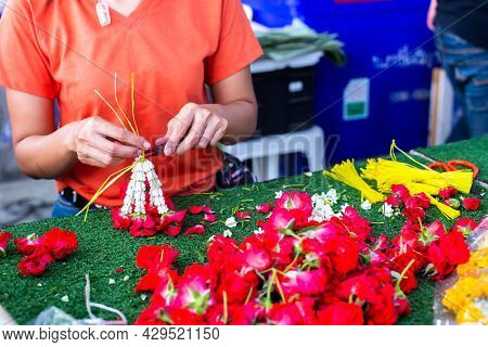 Asian Woman Staff Is Stringing Flower Garlands In Flower Shop