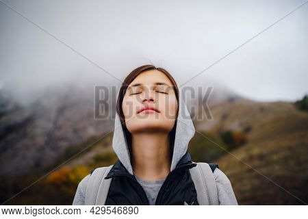 Asian Travel Woman Stands By The Mountain. Cold Weather, Fog On The Hills. Autumn Hike. The Beginnin