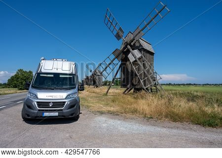 June 27, 2021 - Borgholm, Sweden: A Camper Van In Front Of A Line Of Old Windmills On A Plain. Domes