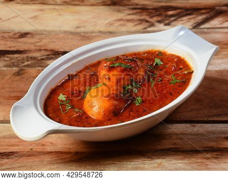 Anda Masala Or Egg Curry Is Popular Indian Spicy Food, Served In A Ceramic Bowl Over Rustic Wooden B