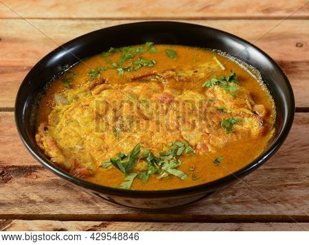 Egg Curry Omelet Is Special Indian Spicy Food, Served In A Ceramic Bowl Over Rustic Wooden Backgroun