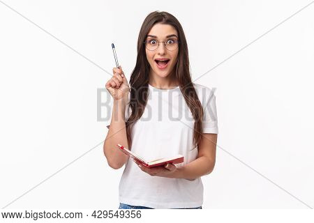 Portrait Of Enthusiastic, Creative Young Woman In Glasses, T-shirt, Raising Pen Up Eureka Gesture, H