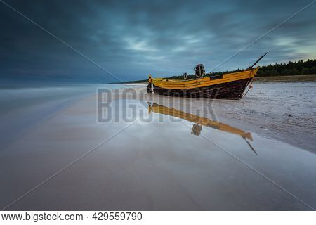 A Fishing Wooden Boat Moored By The Beach In Debki, Sunrise. Baltic Sea, Northern Poland.
