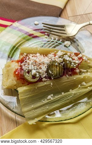 Mexican Steamed Chili And Cheese Masa Tamales Wrapped In Corn Husk Topped With Spicy Tomato Salsa An