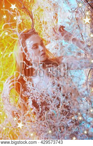 Fairy forest nymph in a magical winter forest illuminated by golden light. Fairy world.