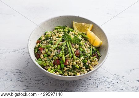 Traditional Middle Eastern Or Arabic Tabbouleh Salad Of Bulgur, Tomatoes, Asparagus, Green Peas And 