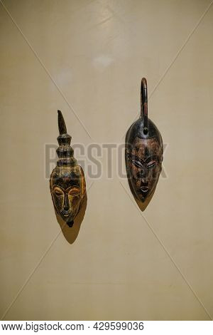 July 2021 Parma, Italy: Two Wooden African Masks On White Wall Close-up In The Museum Of Magnani Roc
