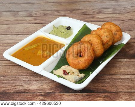 Indian Fried Snack Medu Vada With Sambar And Coconut Chutney In Plate On Rustic Wooden Background, S