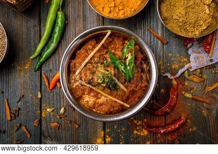 chicken tikka masala Indian food on wooden background with spices top view
