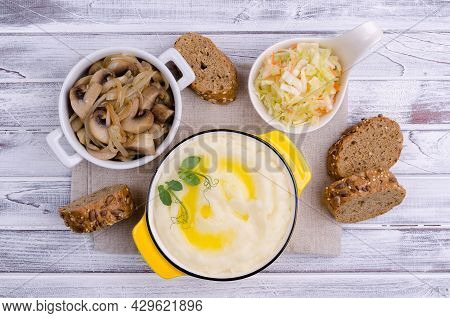 Mashed Potatoes With Butter, Fried Mushrooms With Onions And Salad Of Fresh Vegetables On Light Wood