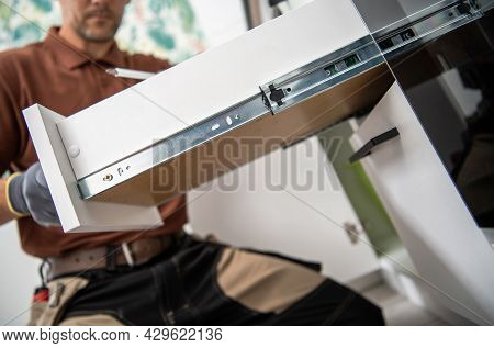 Modern Kitchen Cabinet Drawer Installation By Caucasian Professional Cabinetmaker Technician.