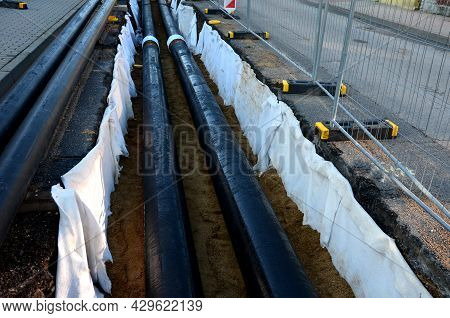 Installation Of Hot Water Pipes For Heating Apartments. Insulated Pipes Are Laid In The Road For San
