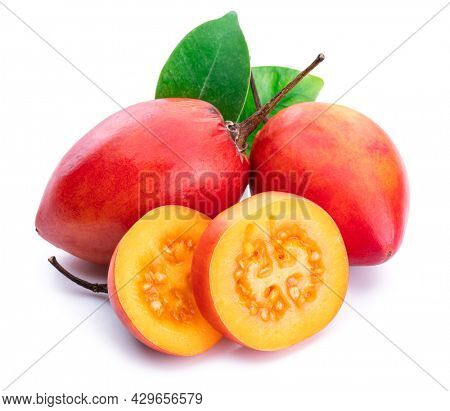 Ripe tamarillo fruits with slices and tamarillo leaves isolated on a white background.