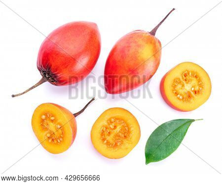 Ripe tamarillo fruits with slices and tamarillo leaves isolated on a white background.