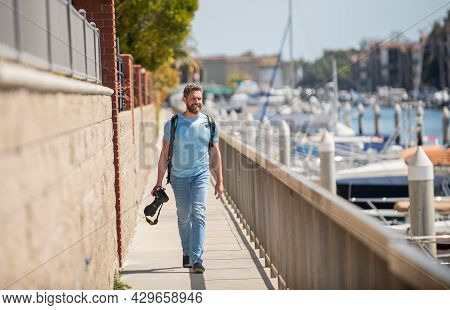 Vacation Photographer. Travel Photographer Promenade Holding Camera. Summer Traveller Go Sightseeing