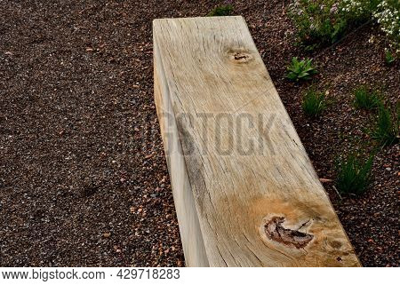 A Wooden Oak Prism Serves As A Bench In The Garden. For Better Drying Of The Wood, Grooves Are Mille