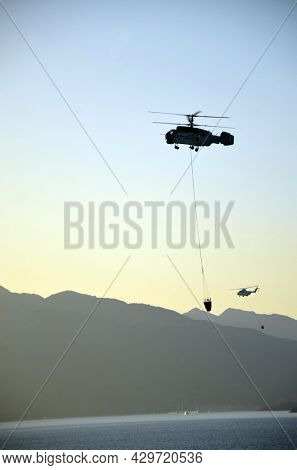 Russian KA-32 helicopter draws water from the sea to extinguish a forest fire. 30 July, 2021. Marmaris,Turkey