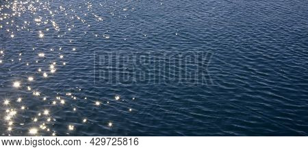 Blue Sea Water With Sun Reflections And Ripples. Blue Sea Water Surface With Ripples And Sun Reflect