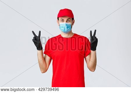 Covid-19, Self-quarantine, Online Shopping And Shipping Concept. Cute Delivery Guy In Red Uniform, F