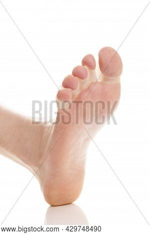 Bare Feet In Bunion Correctors For Treat Pain In Hallux Valgus On White Background.