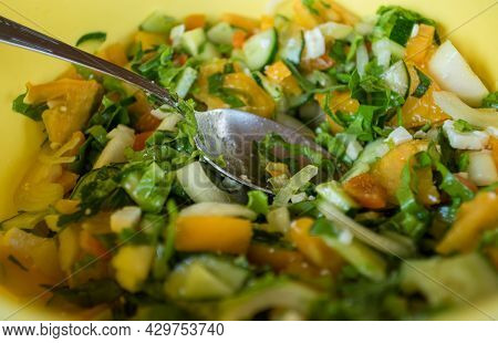 Close View On Yellow Bowl Full Of Vegan Salad And Table-spoon Left Inside With Yellow Tomotoes, Cucu