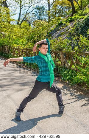Dressing In A Green Long Sleeve Shirt, Scarf, Black Pants And Leather Boots,  Stretching Arms And Tu