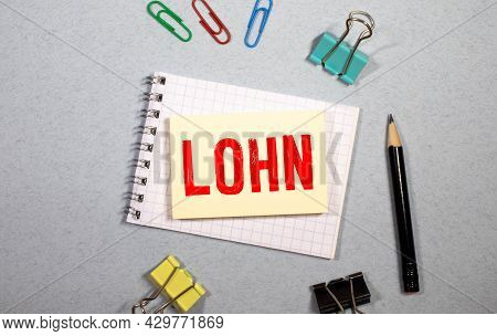 Lohn In German Language, White Chalk Type On Black Board, Euro Money Coin Stacks Of Growth On Wood T
