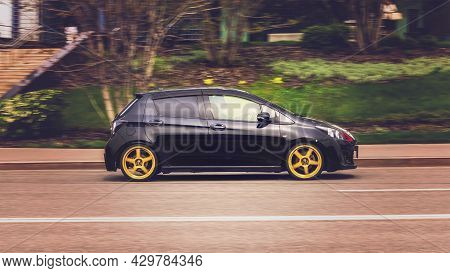Black Toyota Vitz Rs Driving On The City Street On High Speed. Compact Toyota Yaris In Motion, Side 