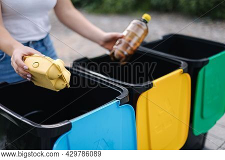 Middle Selection Of Female Hold Two Different Type Of Rubbish, Plastic Bottle And Egg Carton And Tho