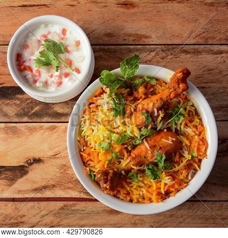 Traditional Hyderabadi Chicken Dhum Biryani Made Of Basmati Rice Cooked With Masala Spices, Served W