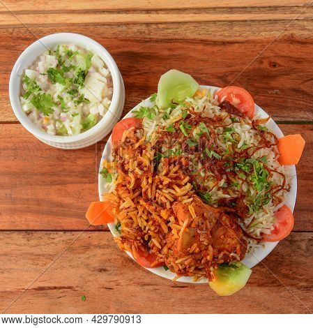 Traditional Hyderabadi Chicken Dhum Biryani Made Of Basmati Rice Cooked With Masala Spices, Served W