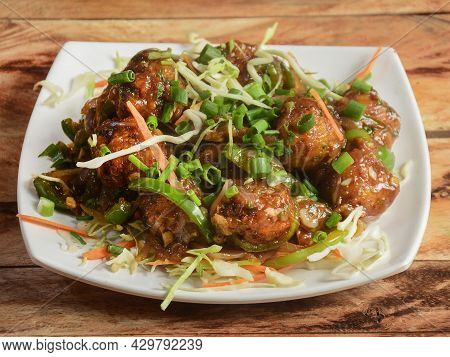 Gobi Manchurian, Popular Indo-chinese Food Made Of Cauliflower Florets, Served In A White Plate Over