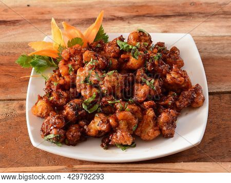 Gobi Manchurian, Popular Indo-chinese Food Made Of Cauliflower Florets, Served In A White Plate Over