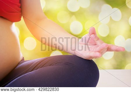 Pregnant Woman Doing Yoga With Nature Bokeh Background