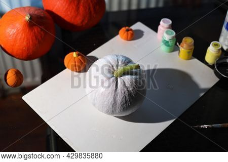 Do It Yourself. Dyi. Women's Hands Painting A Small Pumpkin In White. Making Decorations For Hallowe