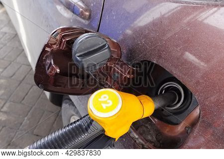 Filling The Car With Gasoline At A Gas Station. A Gun In The Neck Of The Car Tank.