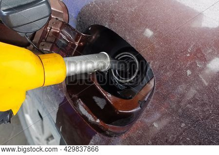 Filling The Car With Gasoline At A Gas Station. A Gun In The Neck Of The Car Tank.
