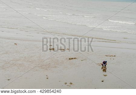 Taean, South Korea; July 30,2021: Unidentified Man Digging In Mud Looking For Sand Crabs During Low 