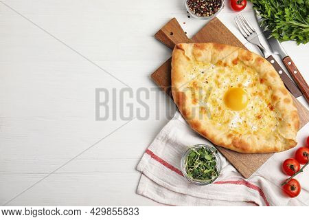 Fresh Delicious Adjarian Khachapuri Served On White Wooden Table, Flat Lay. Space For Text