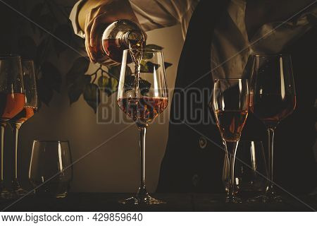 Sommelier Pouring Rose Wine Into Glass At Wine Tasting In Winery, Bar Or Restaurant. Toned Image