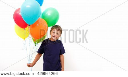 Happy Eight Year Old Boy With An Armful Of Bright Colorfull Balloons Celebrates Birthday. Light Back