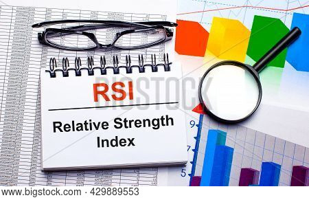 On The Desktop Are Glasses, A Magnifying Glass, Color Charts And A White Notebook With The Text Rsi 