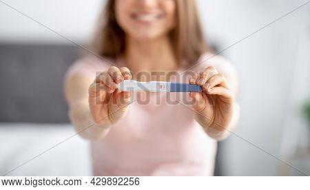 Unrecognizable Young Woman Showing Positive Pregnancy Test, Feeling Happy Over Future Baby At Home, 