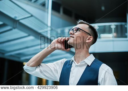 Man With A Takeaway Coffee And A Smartphone Standing In The Lobb