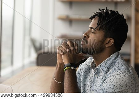 Thoughtful African Male Employee Looks Into Distance And Thinking